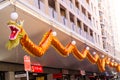 Orange long Dragon Artwork hanging at facade building in Chinatown.